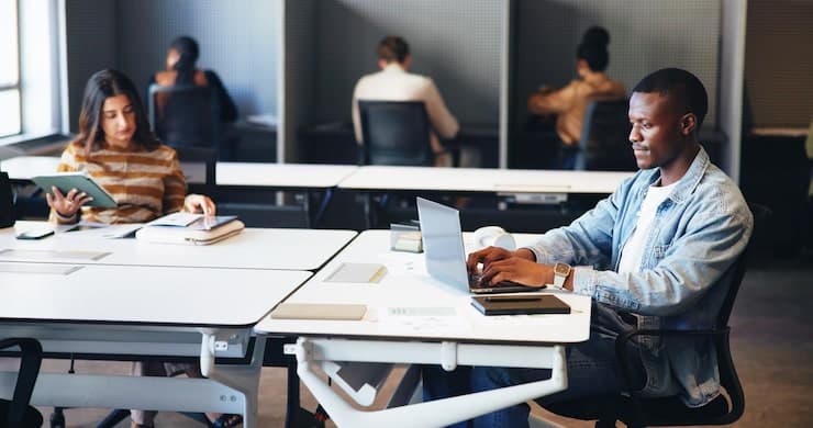 Colleagues working at laptops in a shared office
