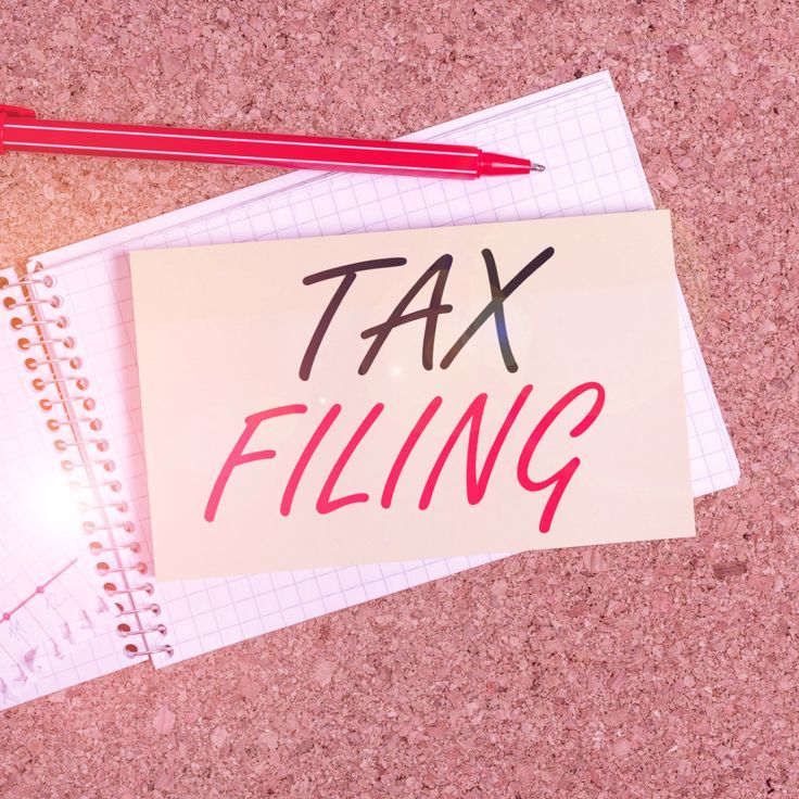 Note reading tax filing on a desk with a pen